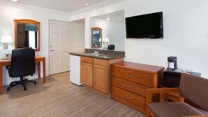 Una cocina compacta con armarios de madera, una encimera y un microondas integrado.