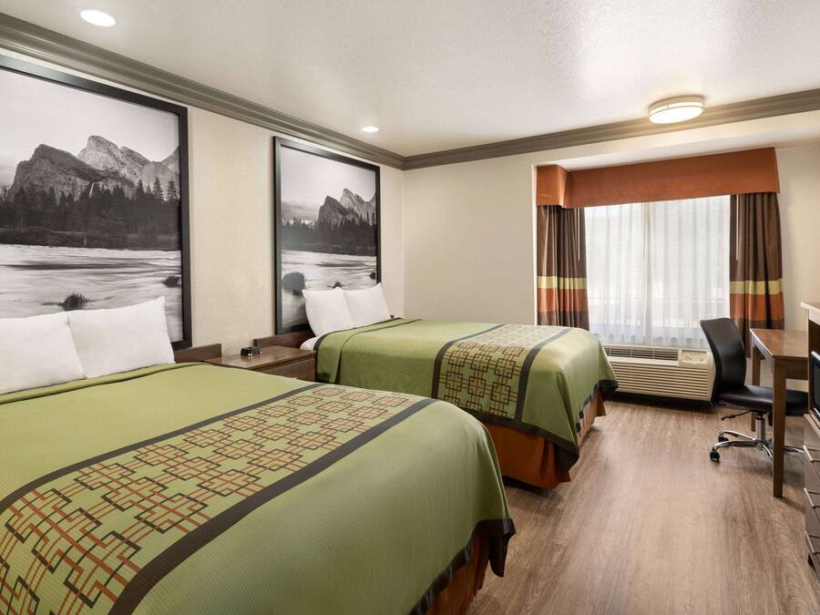 Une chambre d’hôtel avec deux lits, un bureau et une chaise.