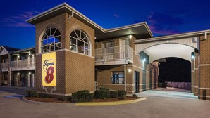 A Super 8 hotel with a brick facade, a large 'Super 8' sign, and a covered entrance. - Super 8 by Wyndham Cabot (Cabot)