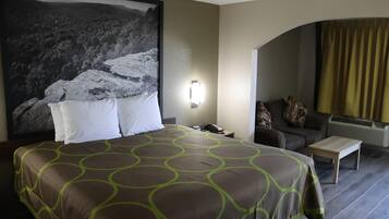 Ein Hotelzimmer mit einem großen Bett, einer Couch, einem kleinen Tisch und einer Wandlampe.