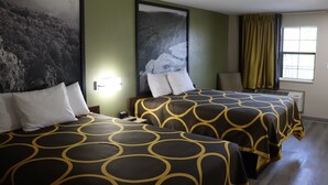 A hotel room with two beds, each with a patterned bedspread, a large framed picture on the wall, and a window with curtains. - Super 8 by Wyndham Cabot (Cabot)