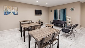 A modern living room with a dining area, a sofa, and a TV. - SureStay Hotel by Best Western Orange (Orange)