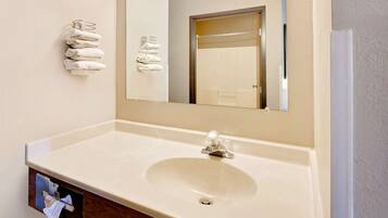 A bathroom with a white sink, a mirror, and a towel rack.