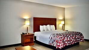 A hotel room with a bed, nightstands, and lamps. - Red Roof Inn & Suites Little Rock (Little Rock)