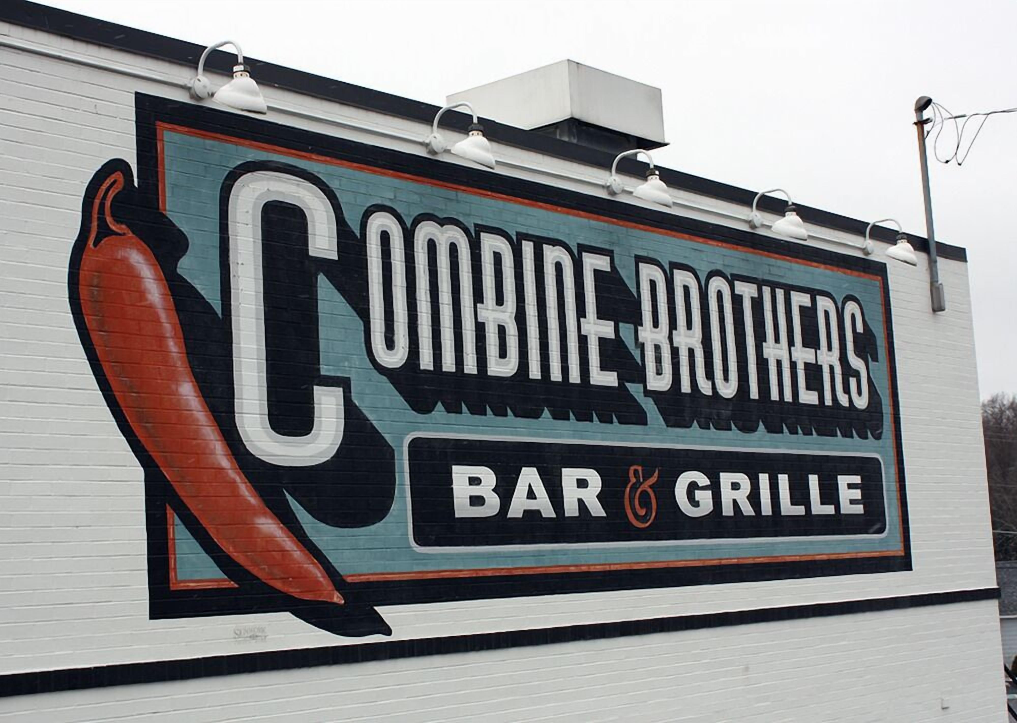 A wall with a sign for Combine Brothers Bar & Grille featuring a chili pepper graphic.