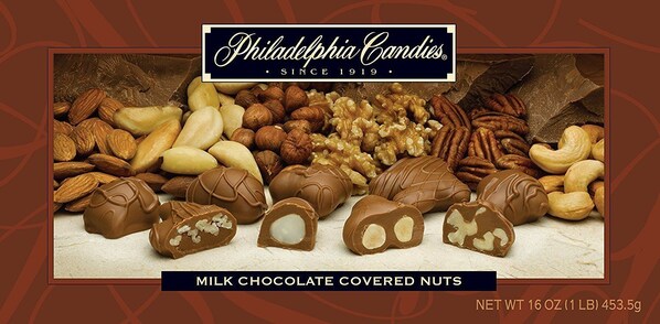 A variety of nuts and chocolate-covered nuts, including almonds, walnuts, pecans, and cashews, with a label indicating they are milk chocolate covered.