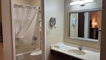 Un bagno con vasca, WC e lavabo con specchio.