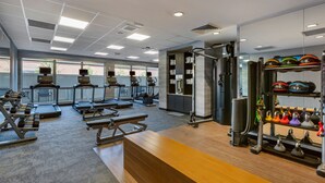 A gym with treadmills, dumbbells, benches, and a weight rack. - Fairfield by Marriott Inn & Suites Sandusky (Sandusky)