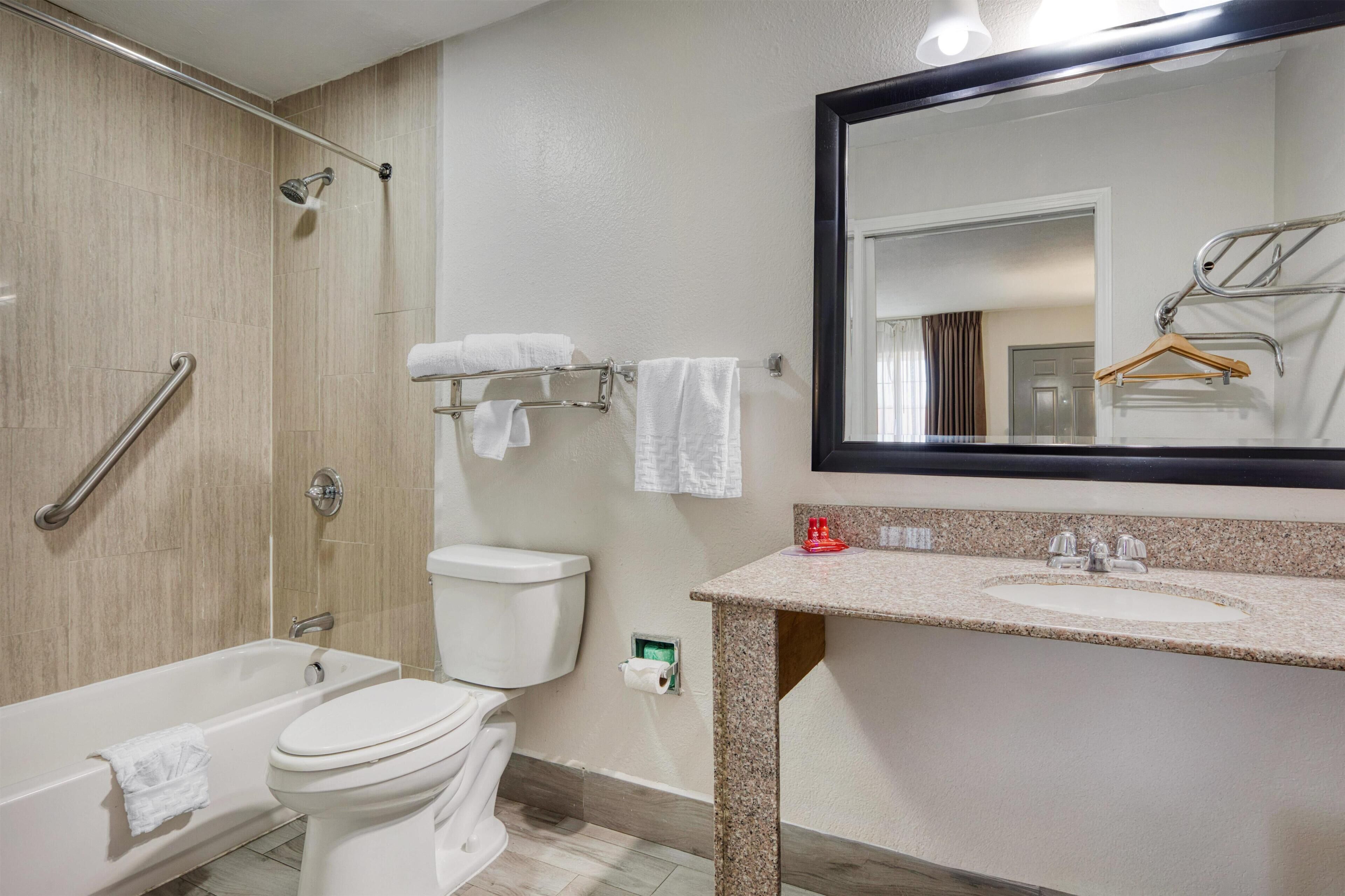 A bathroom with a bathtub, toilet, shower, and sink.