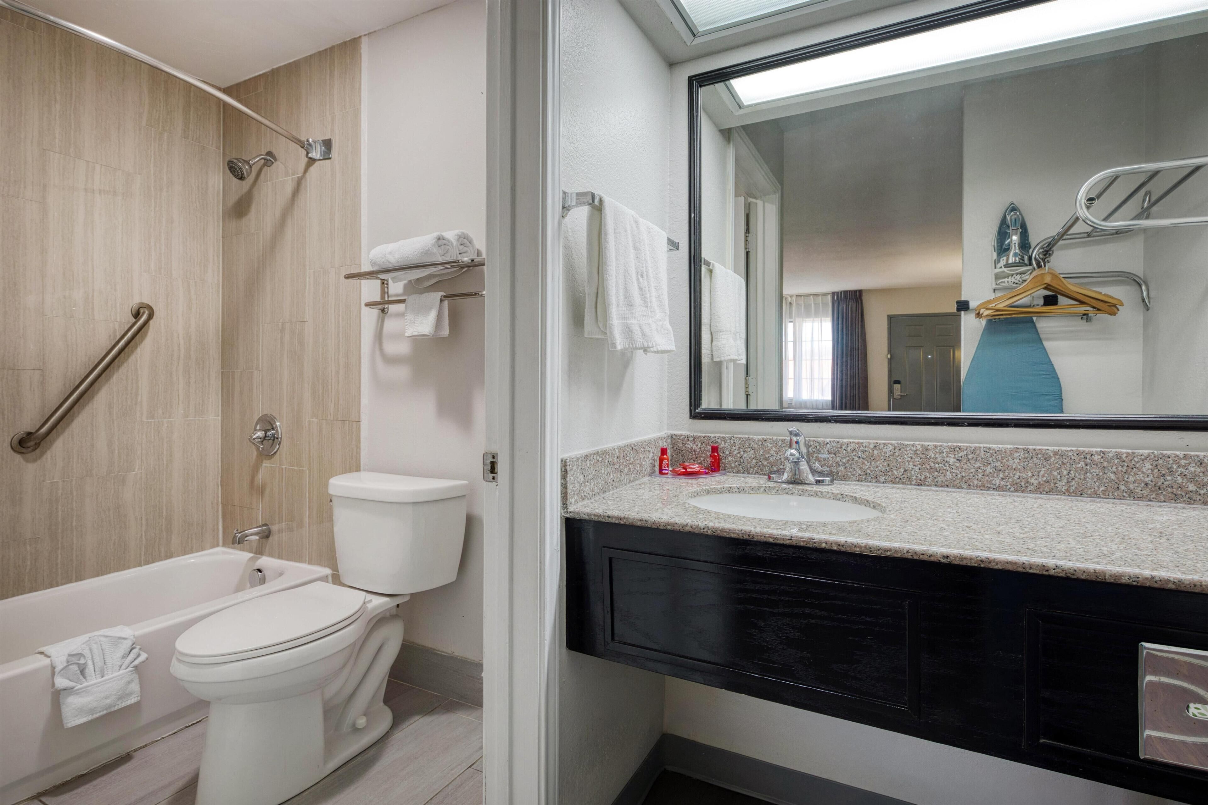 A modern bathroom with a bathtub, toilet, and sink.