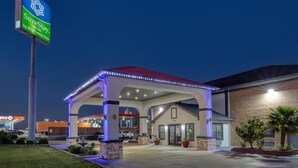 A hotel with a covered outdoor area, a sign for SureStay Hotel by Best Western, and a Circle K convenience store in the background.