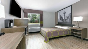 A hotel room with a bed, desk, and a large window. - Super 8 by Wyndham Waxahachie TX (Waxahachie)