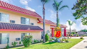 A hotel with a red-tiled roof, a 'Super 8' sign, and a well-maintained lawn.