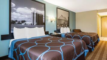 A hotel room with two beds, a large window, and a framed picture on the wall.