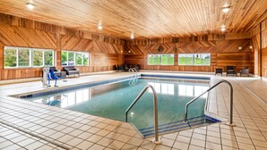 Une piscine intérieure avec des murs en bois et un revêtement de sol carrelé.