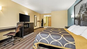 Une chambre d’hôtel comprenant un lit, un bureau avec une chaise, une télévision et une armoire.