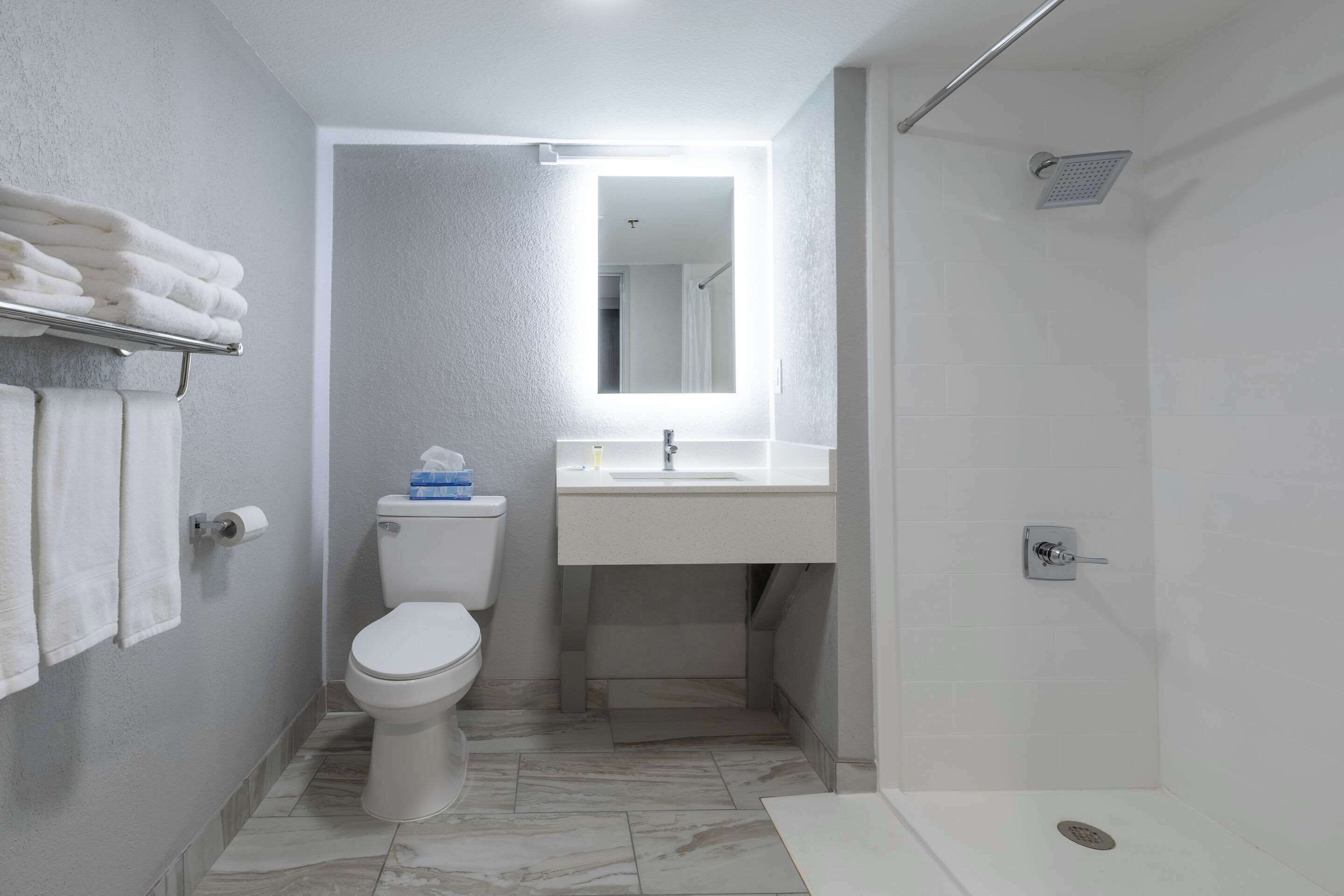 A modern bathroom with a toilet, sink, and shower.