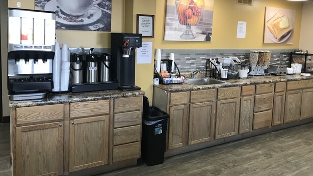 Ein Café mit einer Kaffeemaschine, Espressotassen, einem Spülbecken und einem Mülleimer.