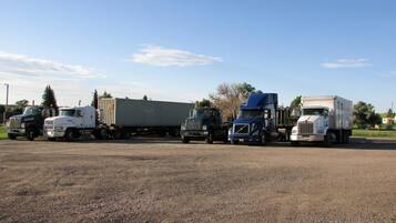 A parking lot with several trucks and a trailer.
