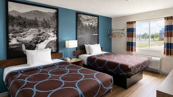 Una habitación de hotel con dos camas, una ventana con cortinas y obras de arte en las paredes.