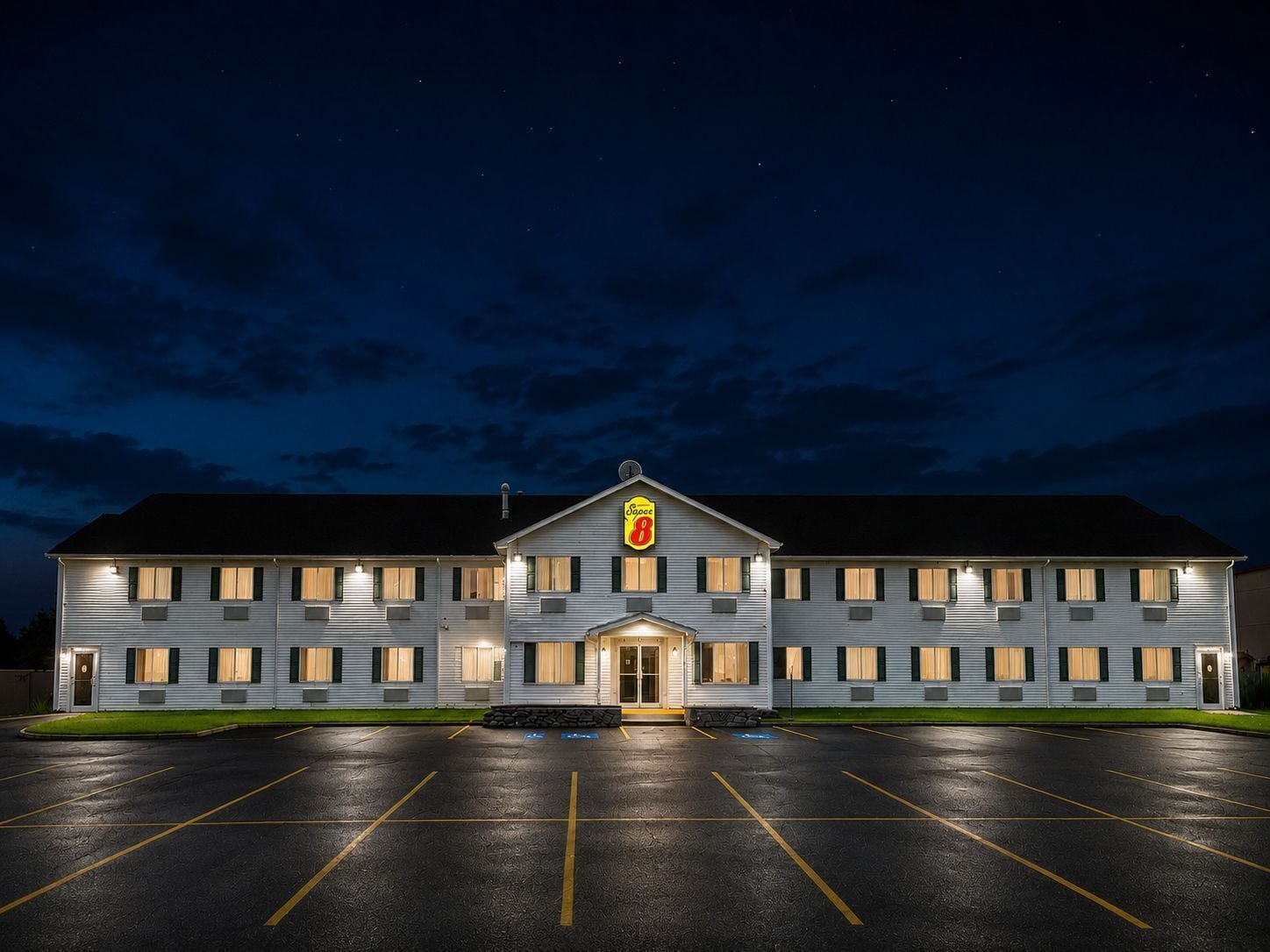 Ein Motel mit großem Parkplatz und einem Schild, das die Nummer 8 anzeigt.