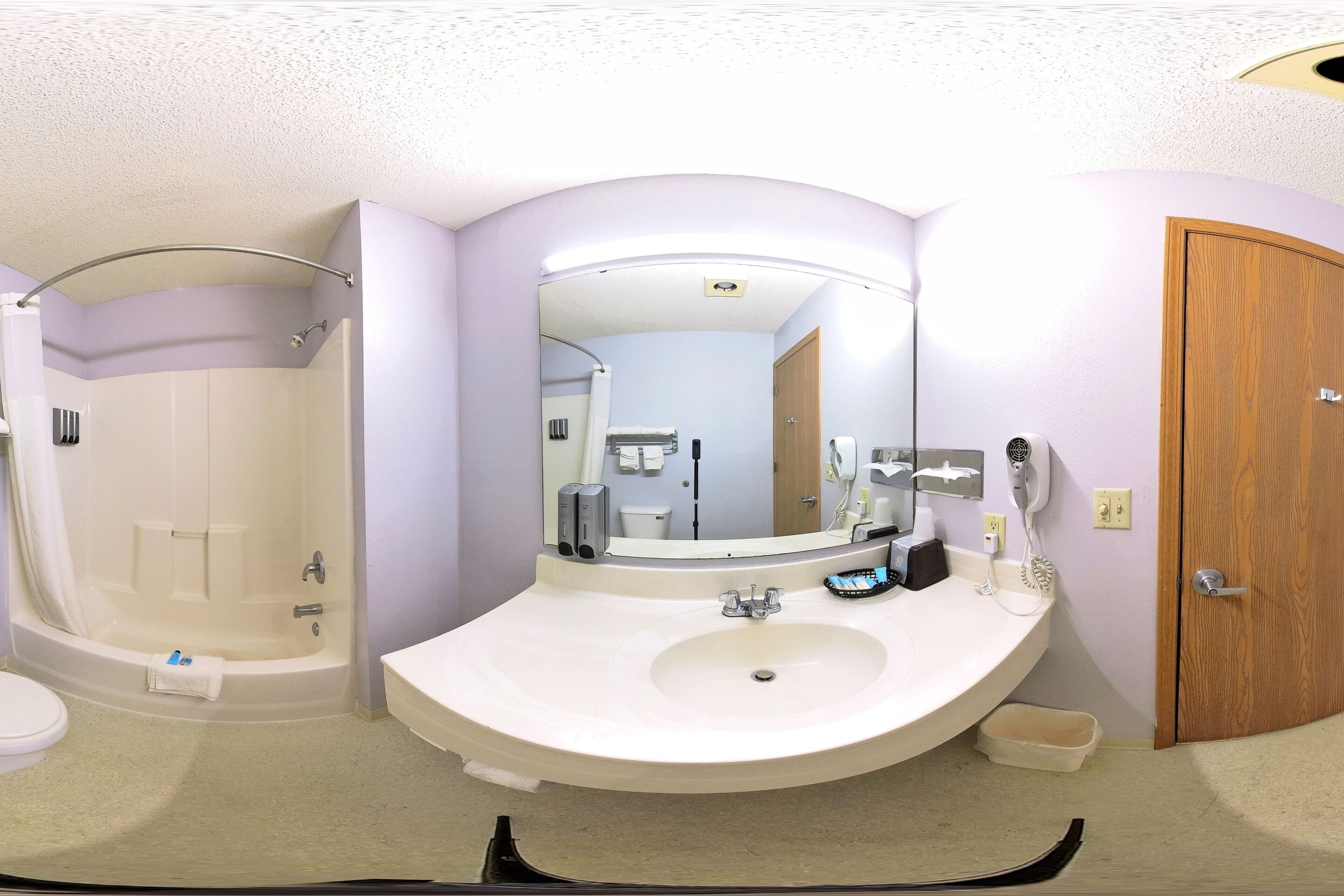 Un baño con bañera, lavamanos y espejo.