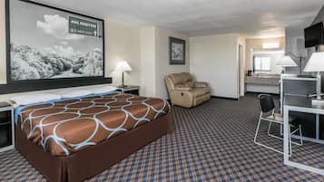A hotel room with a large bed, a desk with a chair, a TV, and a sign indicating the direction to Arlington.