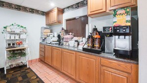 A kitchen with wooden cabinets, a coffee machine, and a refrigerator.