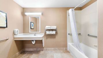 A bathroom with a sink, mirror, towel rack, and shower.