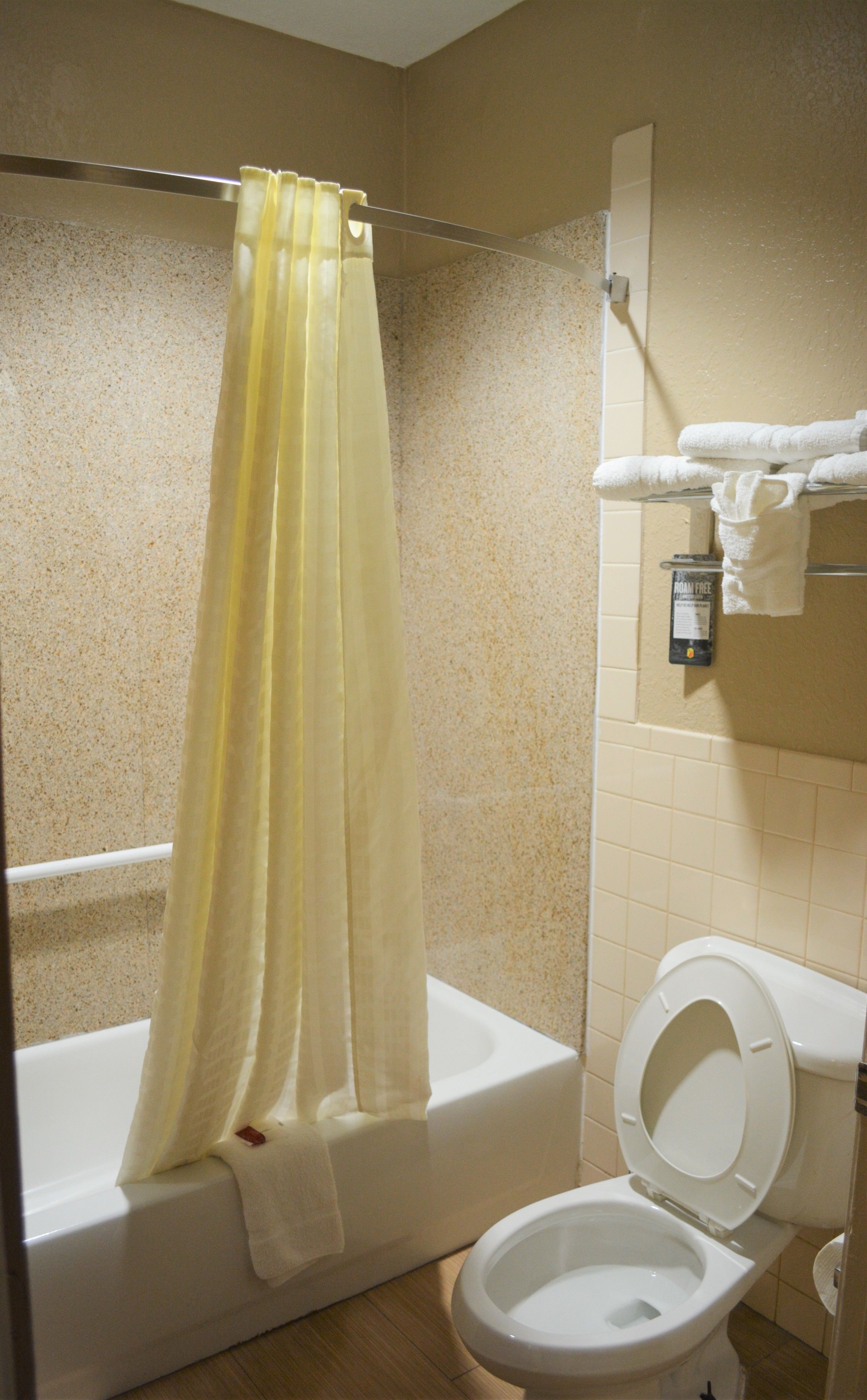 Un baño con bañera, inodoro y cortina de ducha.