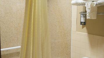 Un baño con bañera, inodoro y cortina de ducha.