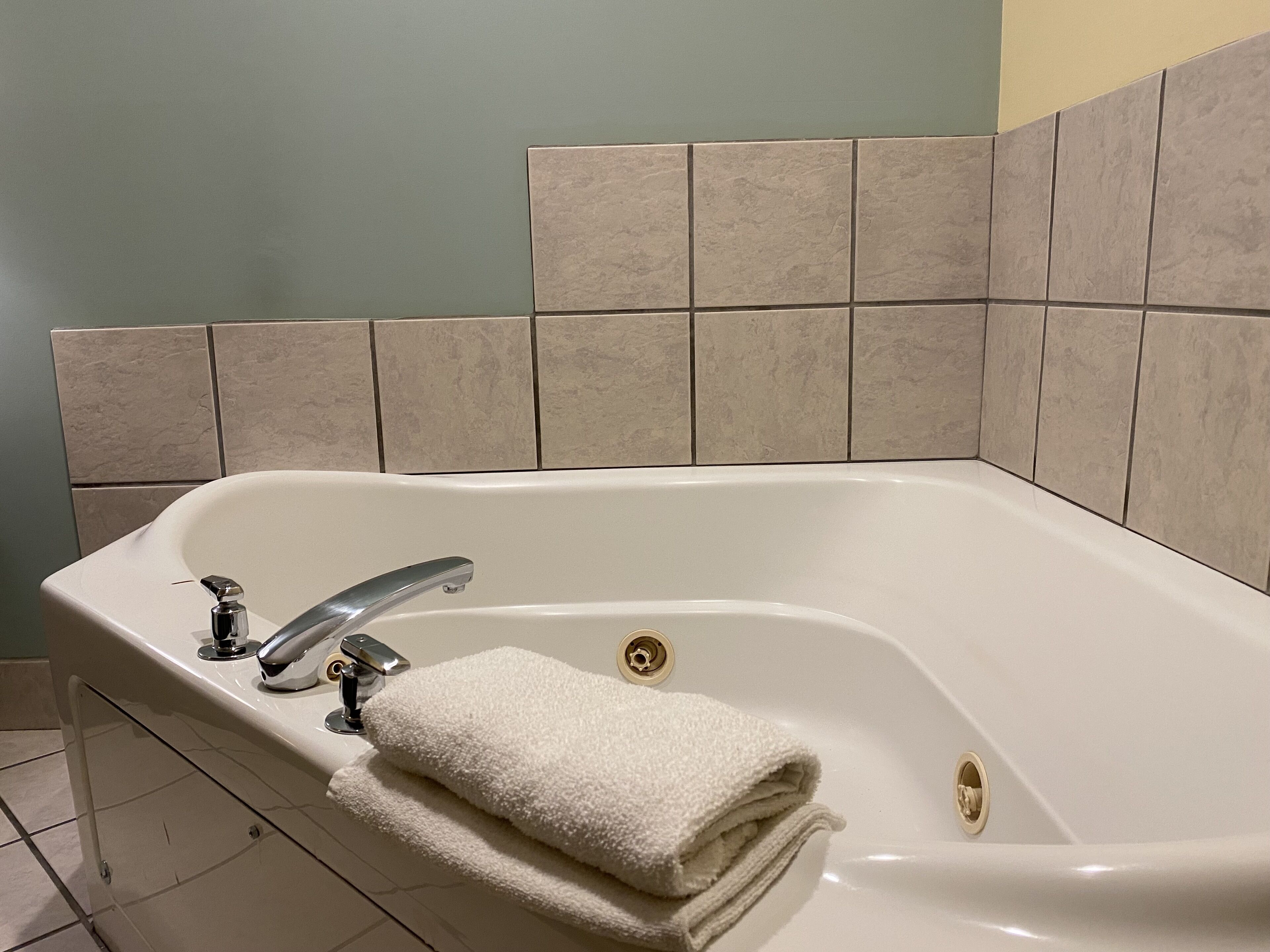 A modern bathroom with a freestanding bathtub, a handheld showerhead, and a towel rack.