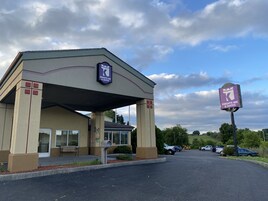 Edificio de Knights Inn & Suites con entrada cubierta, estacionamiento y un letrero con el nombre del hotel.