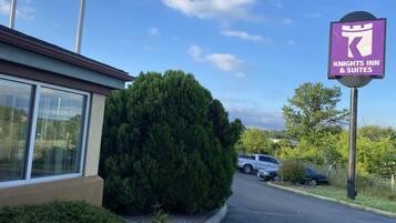 A Knights Inn & Suites sign, a parking lot, and a building with large windows.