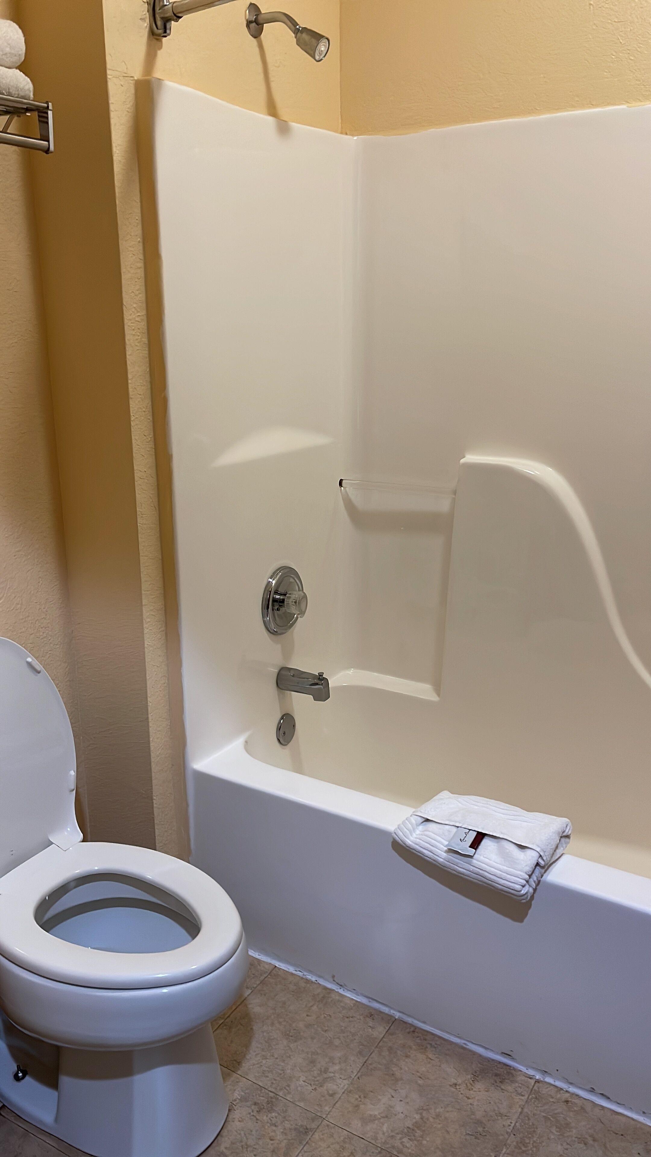 A bathroom with a white toilet, a bathtub, and a towel rack.