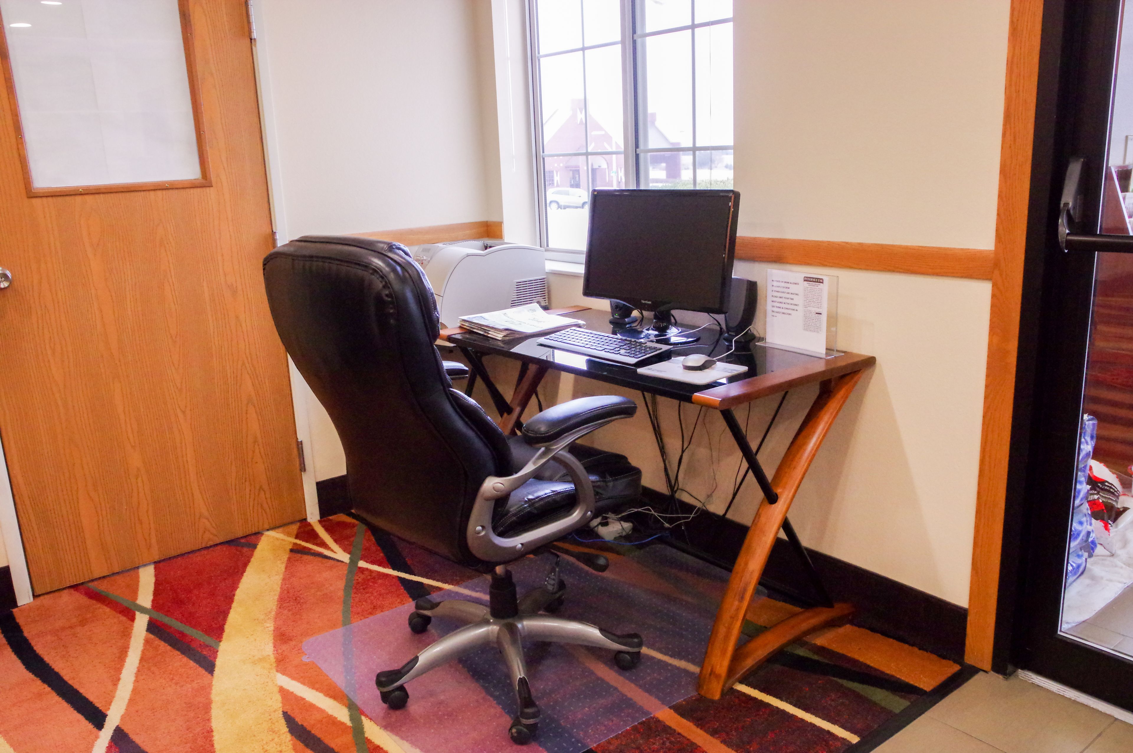 A room with a desk, computer, and office chair.