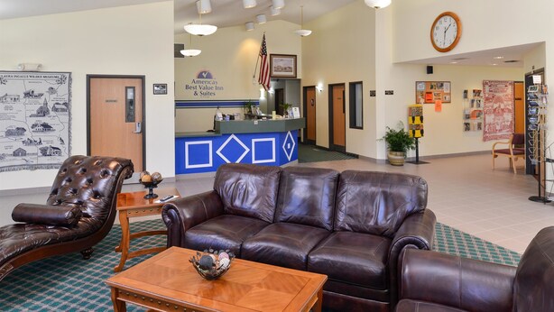 A lobby with leather sofas, a reception desk, a clock, and a map of the museum. - Americas Best Value Inn & Suites Spring Valley (Spring Valley)