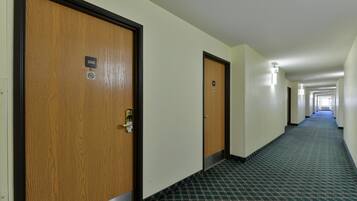 A hotel hallway with wooden doors, numbered 208 and 209, and a patterned carpet.