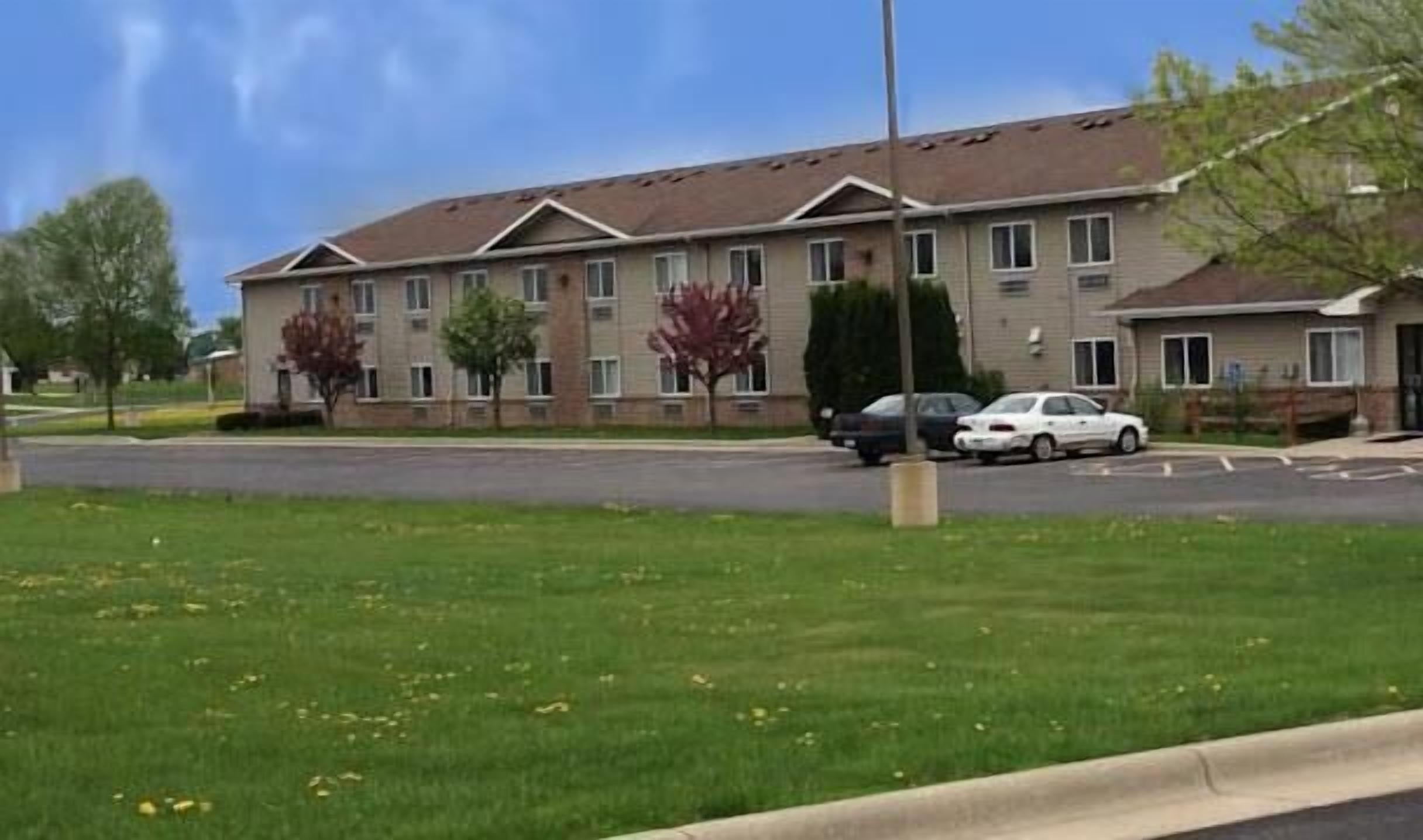 Un edificio residencial de varios pisos con fachada de ladrillo, varias ventanas y techo plano.