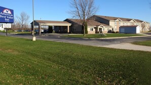 A large, single-story motel with a covered parking area and a grassy lawn. - Americas Best Value Inn & Suites Spring Valley (Spring Valley)