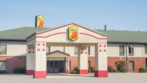 A Super 8 motel with a red and white facade, a prominent 'Super 8' sign, and a green roof. - Super 8 by Wyndham Grayson (Grayson)