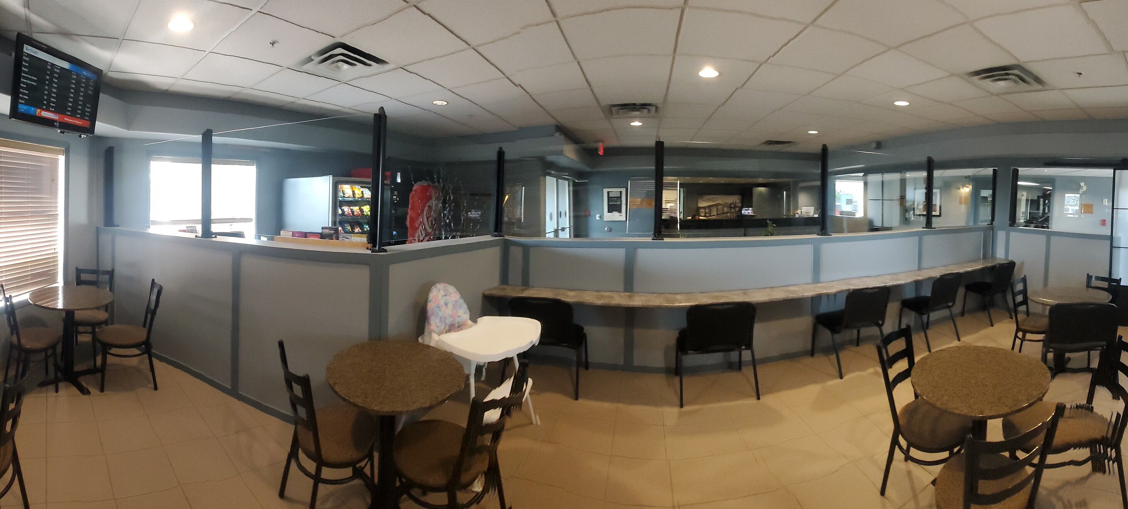A restaurant with a counter, booths, and tables.