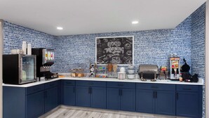 A kitchen with blue cabinets, a chalkboard with 'Good Morning' message, and various appliances. - AmericInn by Wyndham Eagle River Downtown (Eagle River)