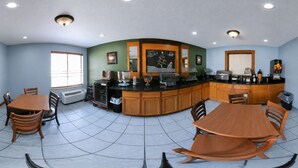 A kitchen with a curved island, wooden cabinets, a window, and a tiled floor.