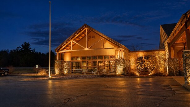 A building with a large entrance, stone walls, and a flagpole.
