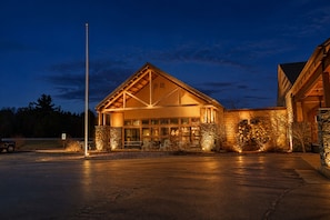 A building with a large entrance, stone walls, and a flagpole. - Coratel Inn & Suites by Jasper Black River Falls (Black River Falls)