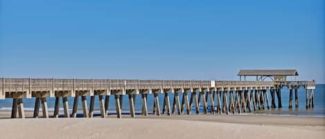 A pier extending into the ocean with a covered structure at the end.