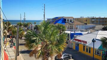 A street view with a building named "Lighthouse Pizza" and a palm tree in the foreground.