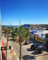 A street view with a building named "Lighthouse Pizza" and a palm tree in the foreground.