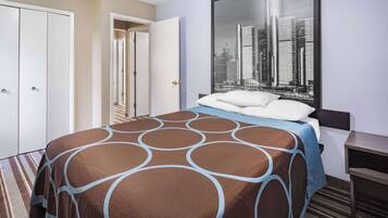 Habitación de hotel con cama, vista panorámica de la ciudad, armario y escritorio.